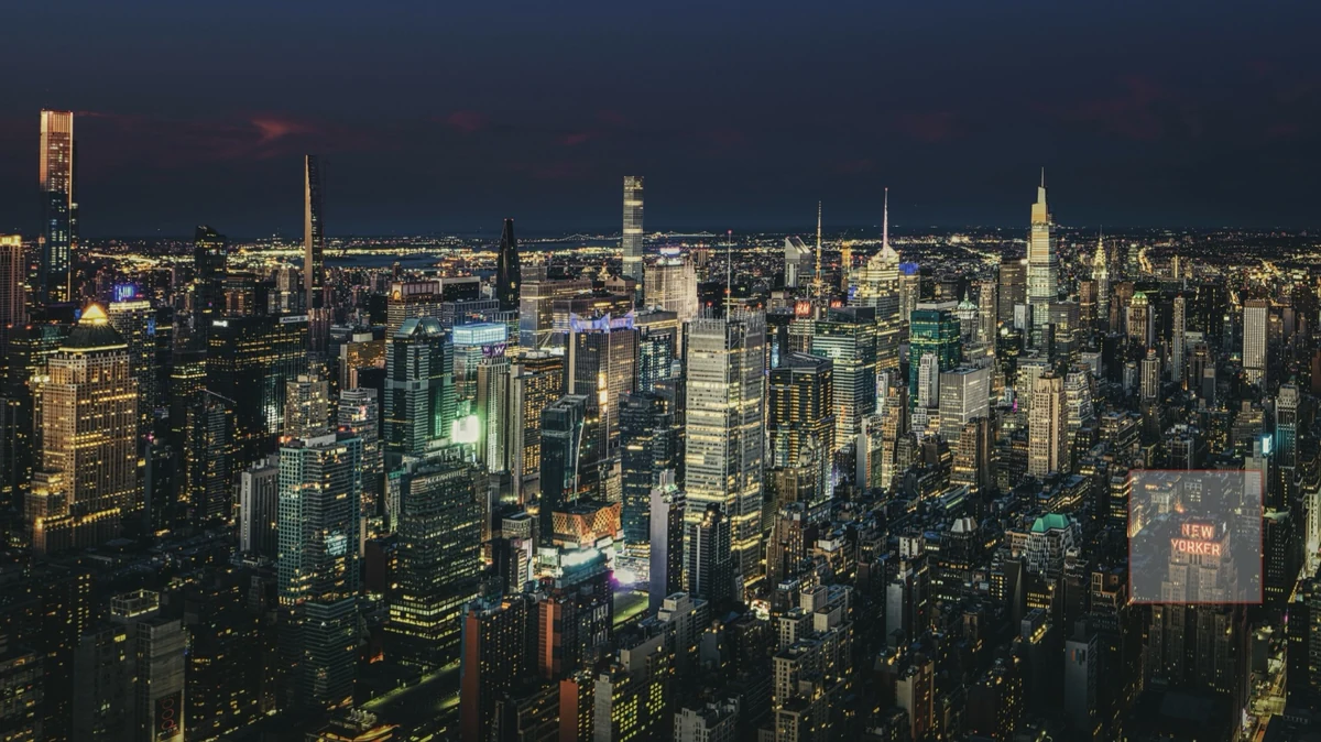 A night skyline, with a small square around one lit rooftop sign marking the area enlarged above